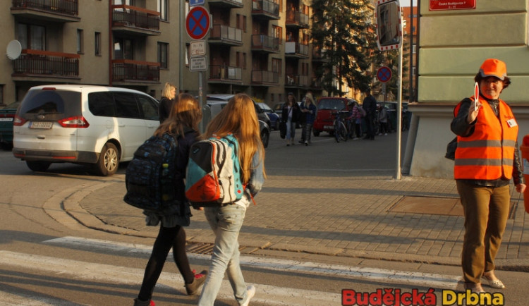 Dobrovolníci pomáhají dětem na přechodech