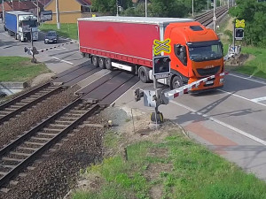 VIDEO: Řidič kamionu ignoroval červenou na přejezdu, kvůli vlaku pak prorazil závory