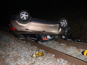 FOTO: Muž sjel ze silnice a auto spadlo na koleje. Při nehodě zranil sebe i svého pejska