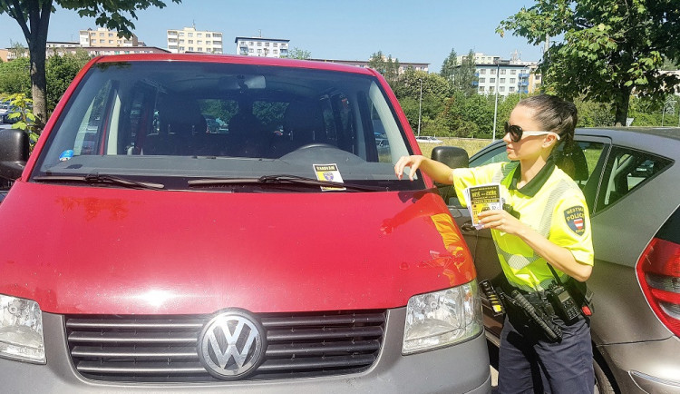 Strážníci dávají za stěrače varovné letáčky