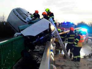 FOTO: Auto po nehodě zůstalo viset na zábradlí mostu. Řidiče musel transportovat vrtulník