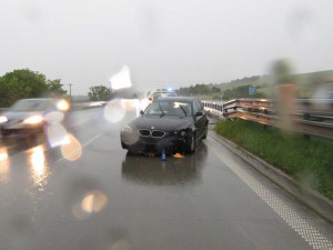 VIDEO: Řidič BMW nezvládl jízdu v dešti, auto pak na dálnici obcházel bez reflexní vesty