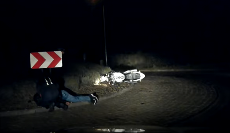 Policista pomáhající motorkáři.