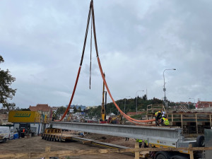 Brnu roste další úsek městského okruhu. Dělníci jeřábem usazují nosníky nového mostu