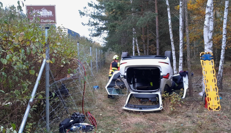 Osobák po střetu s náklaďákem vyletěl z dálnice, prorazil plot a skončil na střeše. Řidič je těžce zraněný