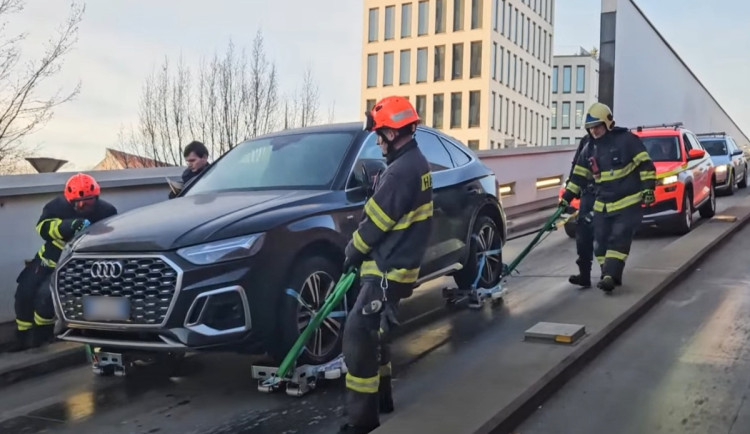 Hasiči odvezli zaparkované auto ze střešních garáží, aby ho mohla naložit odtahovka