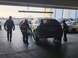 Hasiči odvezli zaparkované auto ze střešních garáží, aby ho mohla naložit odtahovka