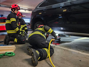 Hasiči odvezli zaparkované auto ze střešních garáží, aby ho mohla naložit odtahovka