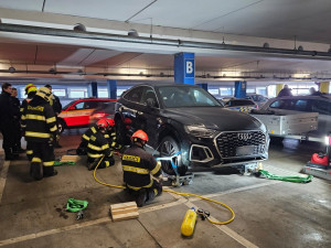 Hasiči odvezli zaparkované auto ze střešních garáží, aby ho mohla naložit odtahovka