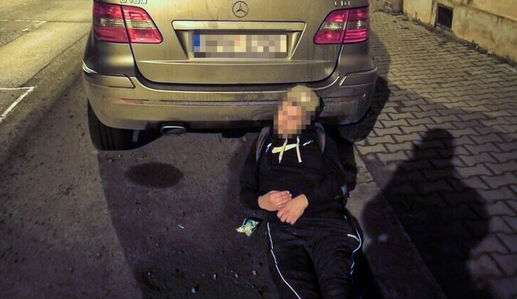 Opilý muž vyděsil kolemjdoucí, zalezl si pod zaparkované auto a zasekl se tam