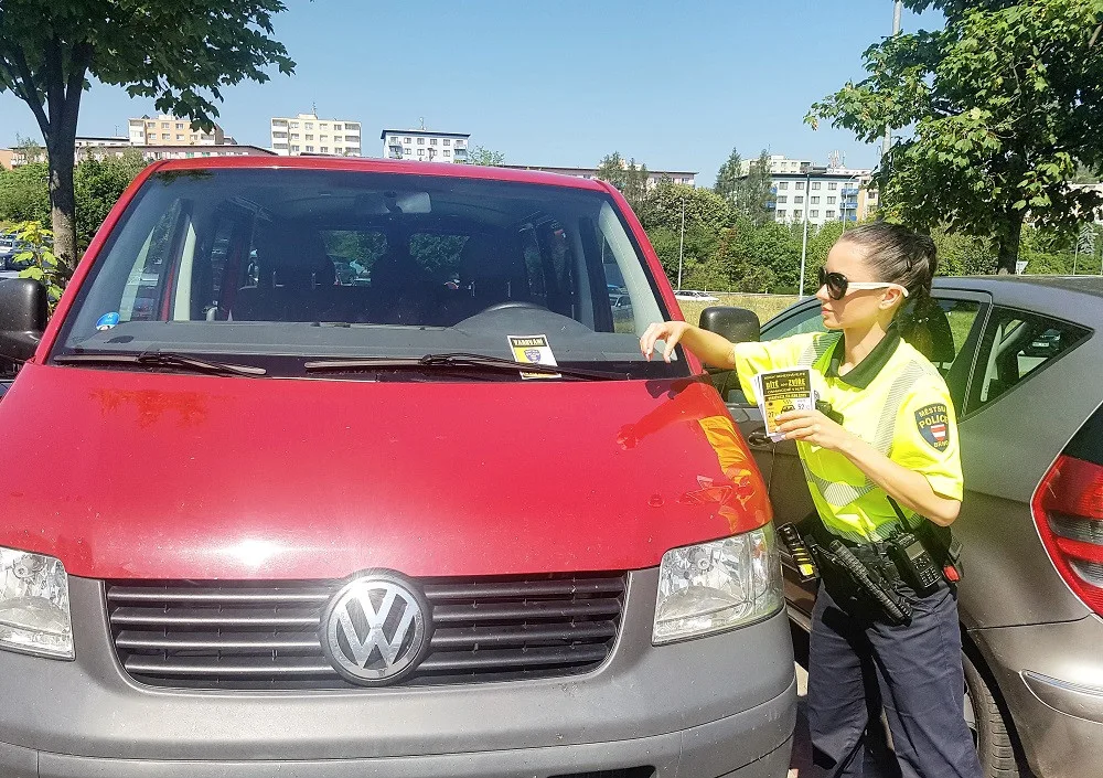 Strážníci dávají za stěrače varovné letáčky