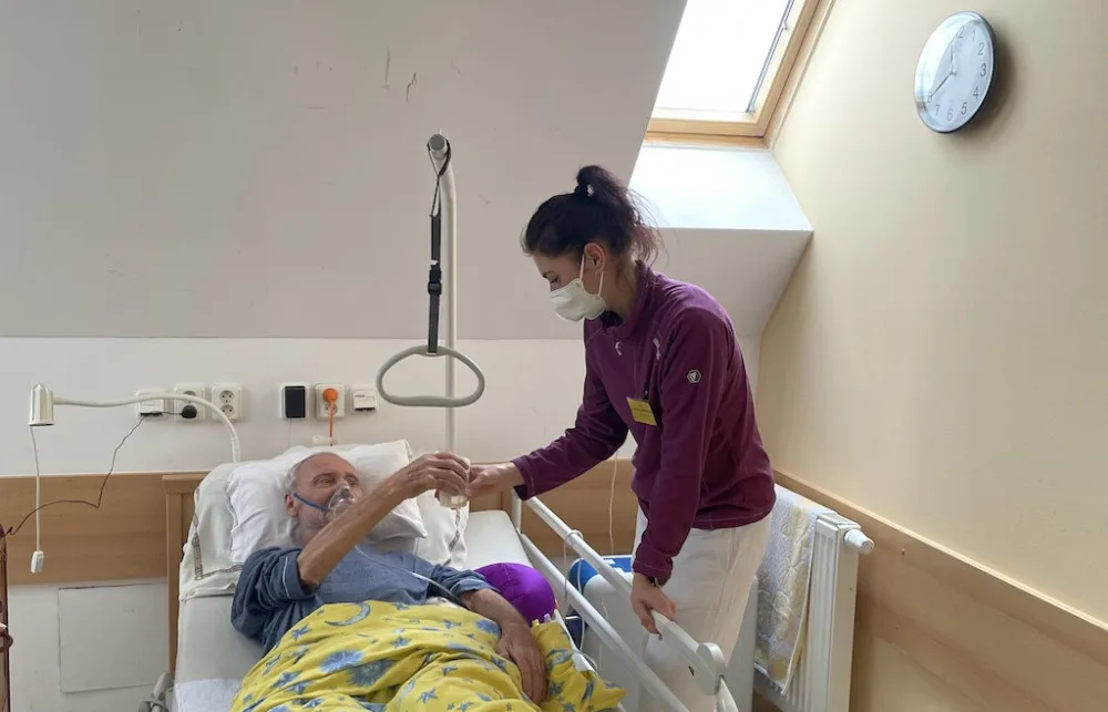 Pacient Jiří Záborský přijímá od zdravotní sestřičky občerstvení