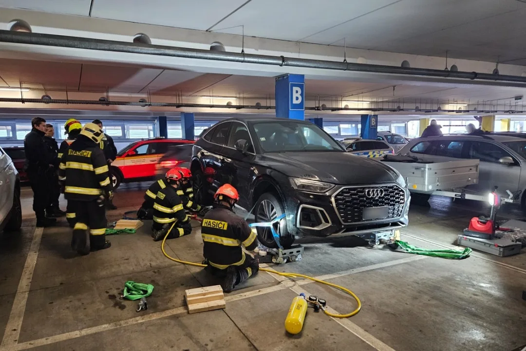 Hasiči odvezli zaparkované auto ze střešních garáží, aby ho mohla naložit odtahovka