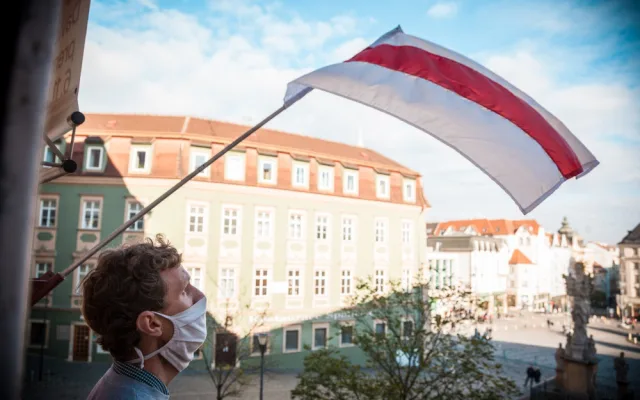 Nad Husou na provázku zavlála běloruská národní vlajka. Divadlo je sídlem ambasády nezávislé běloruské kultury