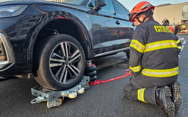 Hasiči odvezli zaparkované auto ze střešních garáží, aby ho mohla naložit odtahovka