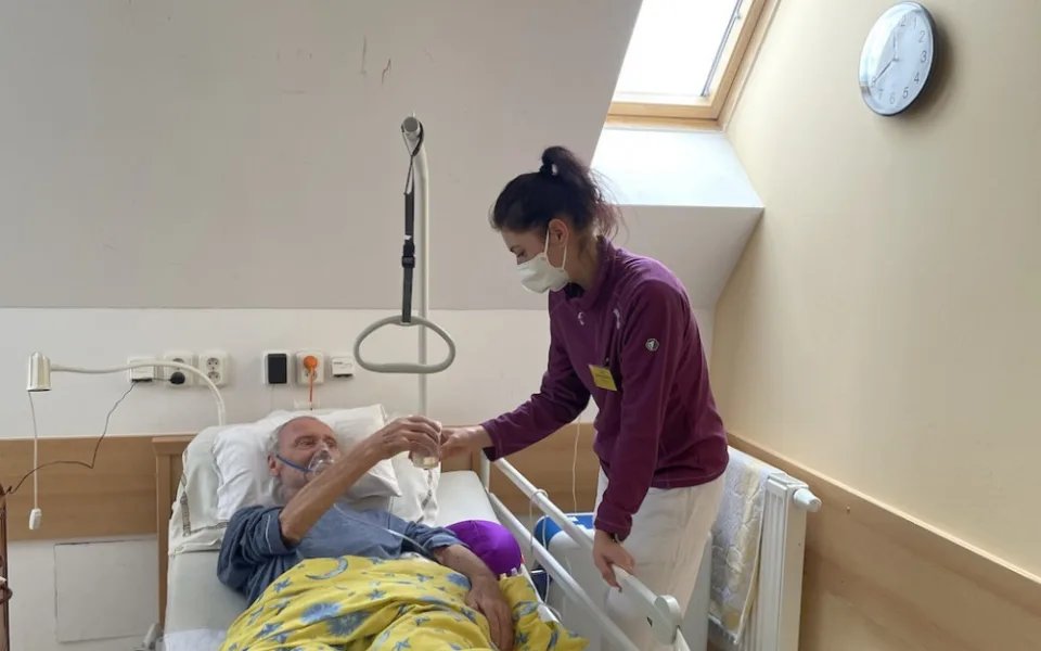 Pacient Jiří Záborský přijímá od zdravotní sestřičky občerstvení