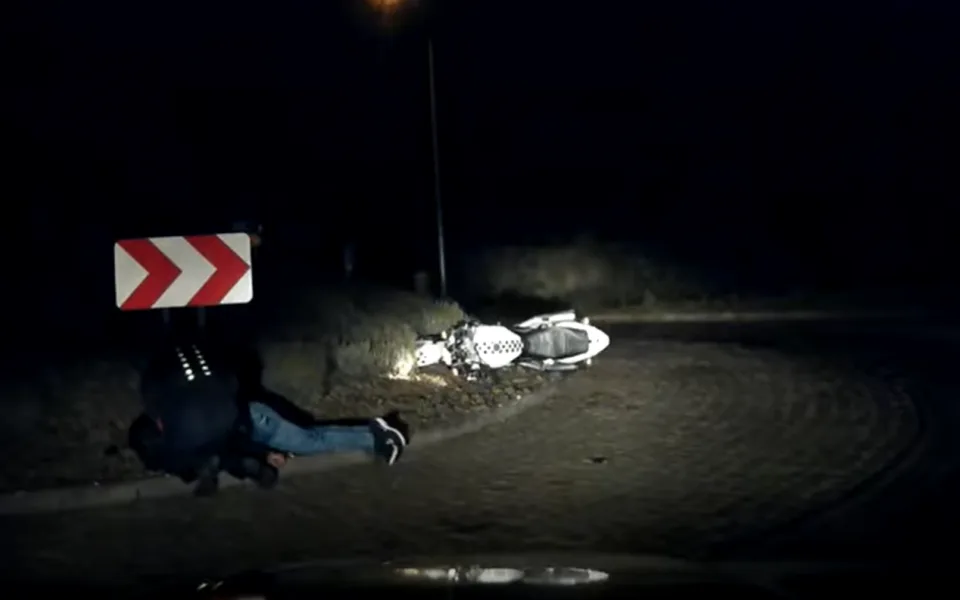 Policista pomáhající motorkáři.