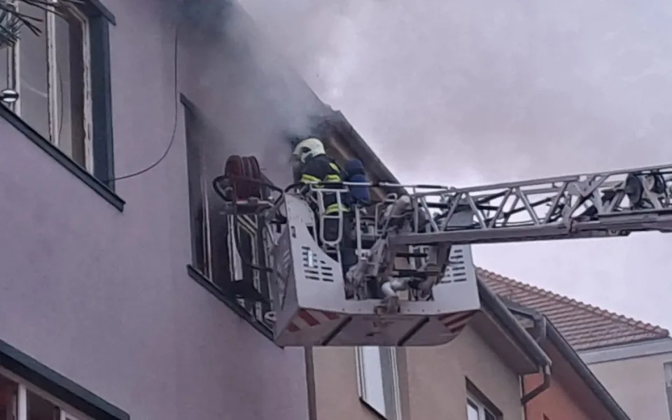 Při požáru bytového domu v Brně zemřel člověk, dalšího hasiči zachránili